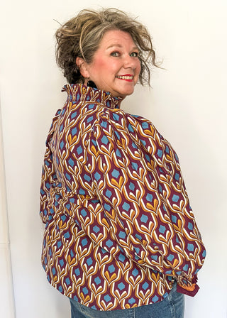 Wine-colored geometric print blouse with long puff sleeves and smocked cuffs.