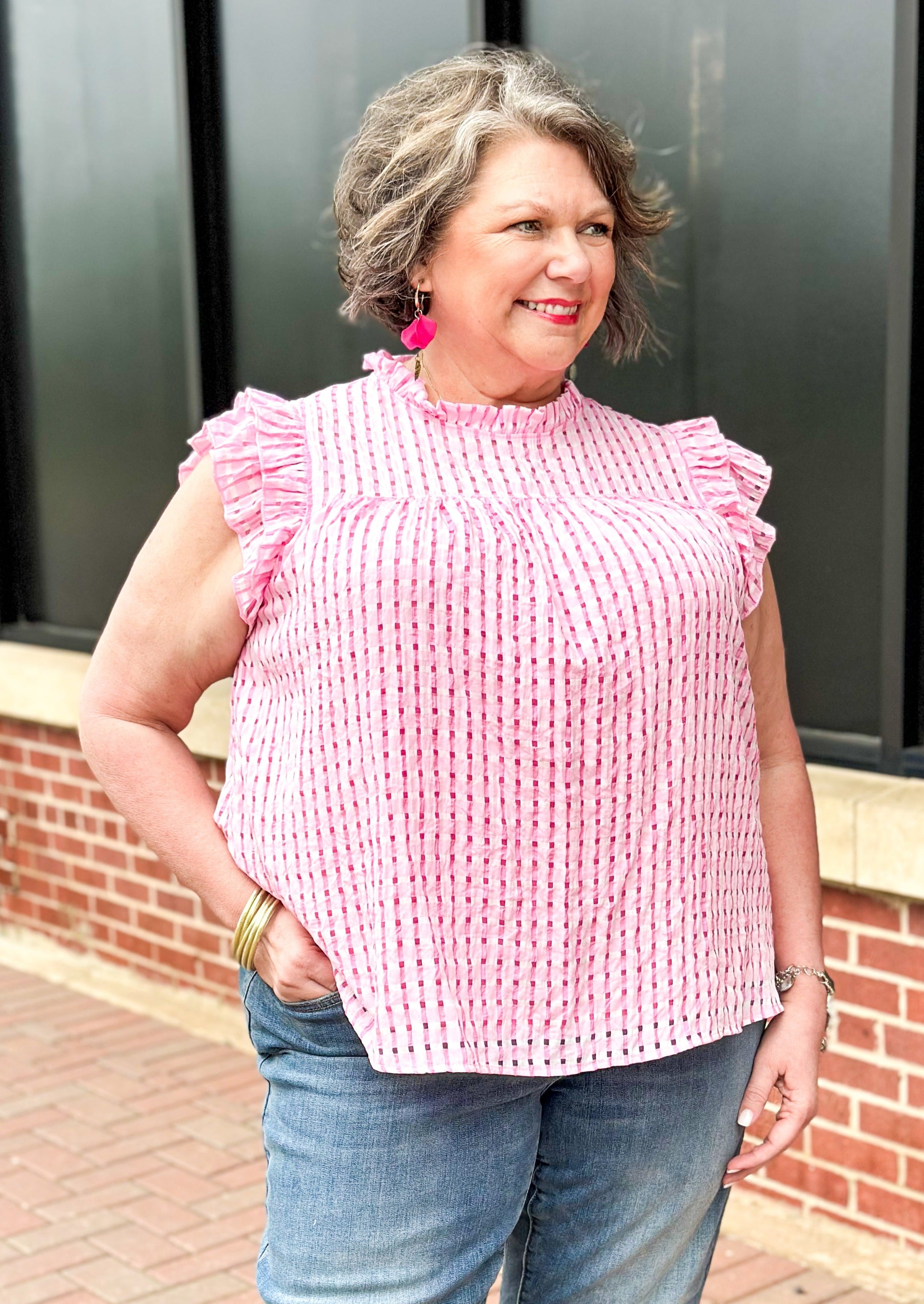 Pink seersucker ruffle sleeve top with ruffle neck and hint of white throughout - top is lined