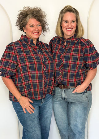 Two women wearing a short sleeve button up top in Navy/Red plaid