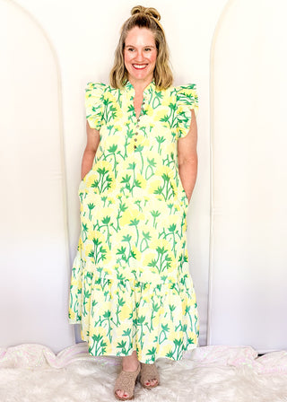 Women’s flowy maxi dress with green and yellow floral pattern and ruffle sleeve detail.