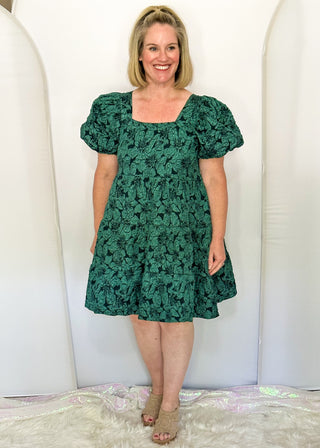 woman wearing Forest green jacquard babydoll dress with square neckline and short sleeves.