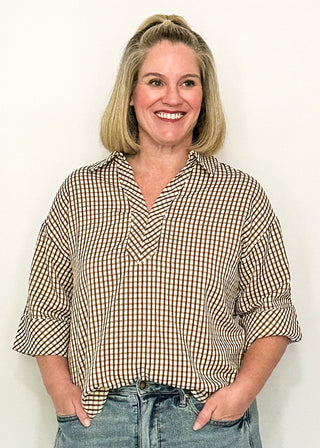 woman modeling a gingham top in brown.