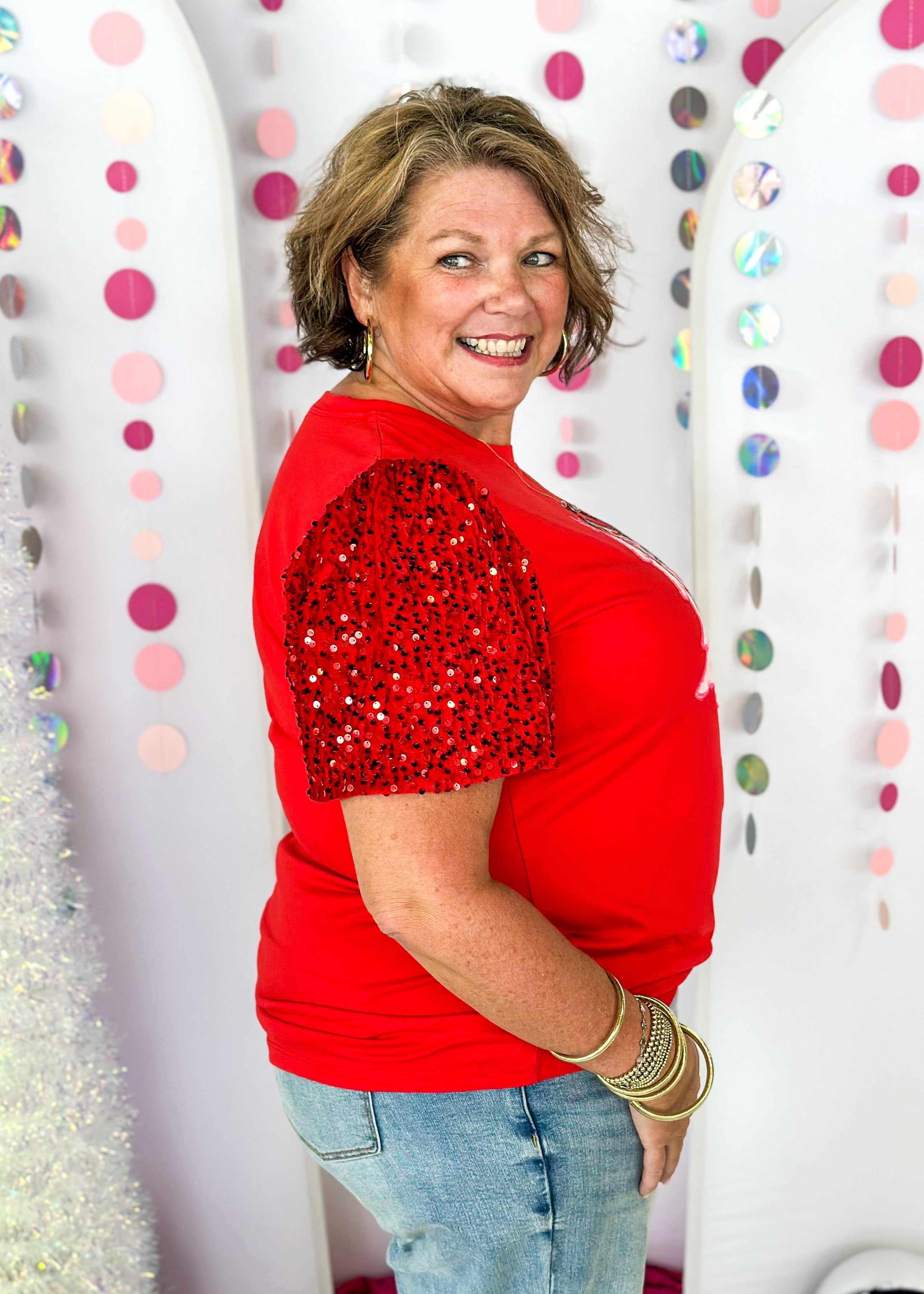 white short sleeve top with iridescent sequin sleeves, round neck, sparkly trio of trees patch on the front