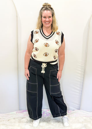 Black balloon style pants with rope drawstring waist. White stitching around pockets and crop cut.