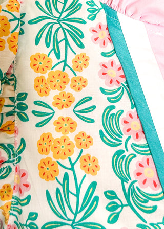 Close up of floral print top with decorative neckline and short ruffle sleeves