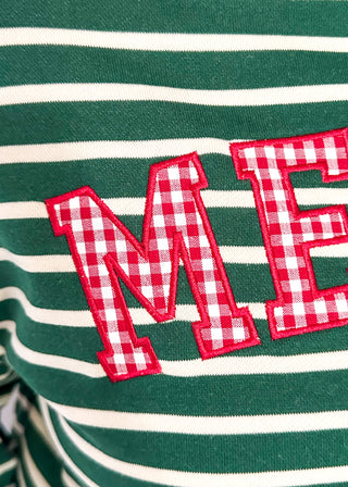 Close-up of a green and white striped knit garment with large red-and-white gingham letters 'ME' outlined in red embroidery.