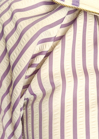 Close up of lavender striped short sleeve 1/4 zip top with lightweight fabric, stripe elastic sleeve and collar detail.