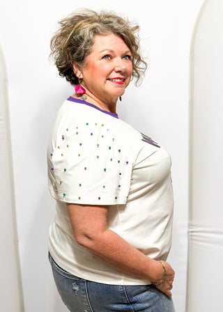 Short sleeve top with pearl accents with sequin "Mardi Gras" wording.