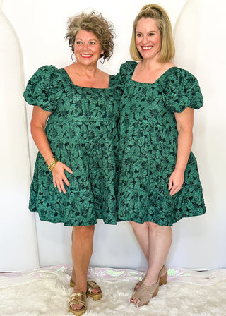 Two women wearing Forest green jacquard babydoll dresses with square necklines and short sleeves.