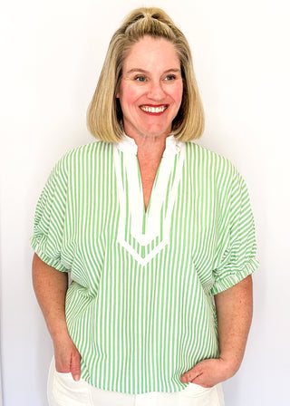 Striped seersucker top in green and white with short sleeves, relaxed fit, and split neckline.
