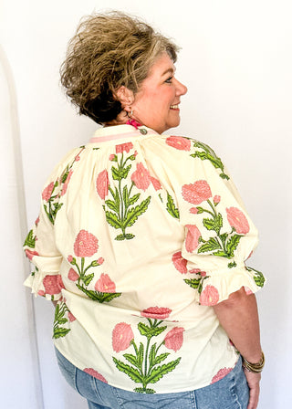 3/4 smocked sleeve cream top with large pink blooms. V-neck with pink trim detail. 