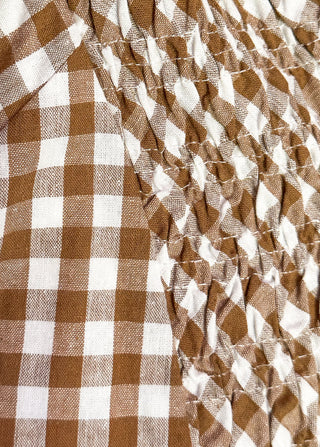 Close up of long brown gingham dress with short sleeves
