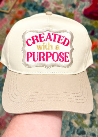 cream baseball hat with khaki bill and created with a purpose embroidered patch - snap closure