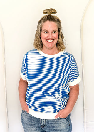 Woman wearing a blue and white striped shirt against a white background