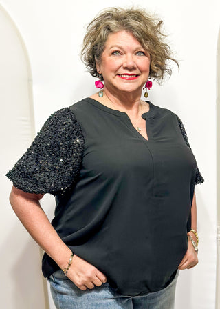 Rose-colored top featuring sparkly sequin puff sleeves and a relaxed, flowy body.