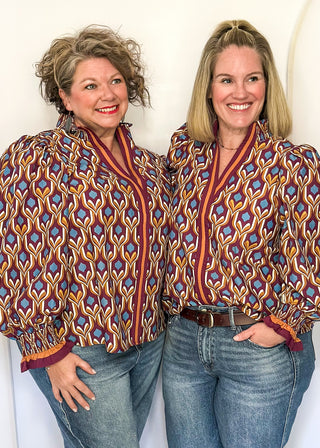 Wine-colored geometric print blouse with long puff sleeves and smocked cuffs.