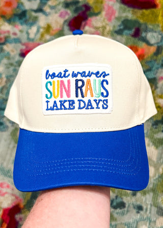 cream baseball hat with blue bill and boat waves, sun rays, lake days embroidered patch - snap closure