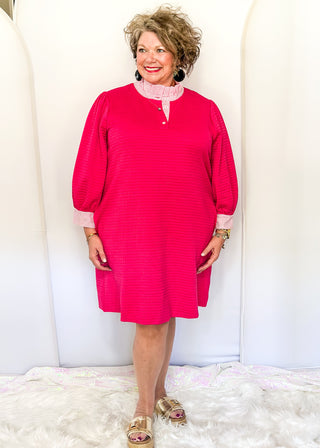 Hot pink quilted dress with striped collar and three-quarter sleeves.