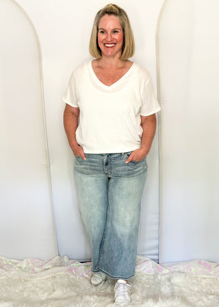 woman wearing denim crop jeans and white tee.