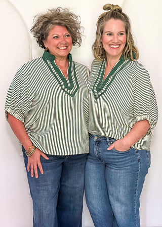 Models are wearing a Hunter green-colored Entro dolman striped top with contrast trim, styled in a relaxed, casual fit.