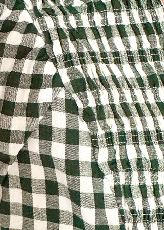 Close-up of a green and white gingham checkered garment with gathered elastic detailing, likely a shirt or blouse.