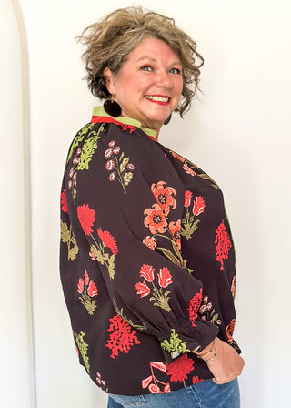 black button up long sleeve top with red flowers and greenery - red and green scalloped stripe detail along collar and down front 