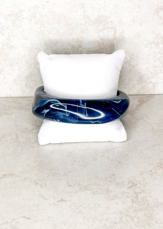 Navy bangle bracelet displayed on a stand 