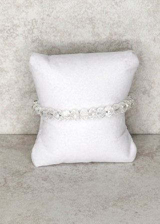 Clear beaded bracelet displayed on a stand 