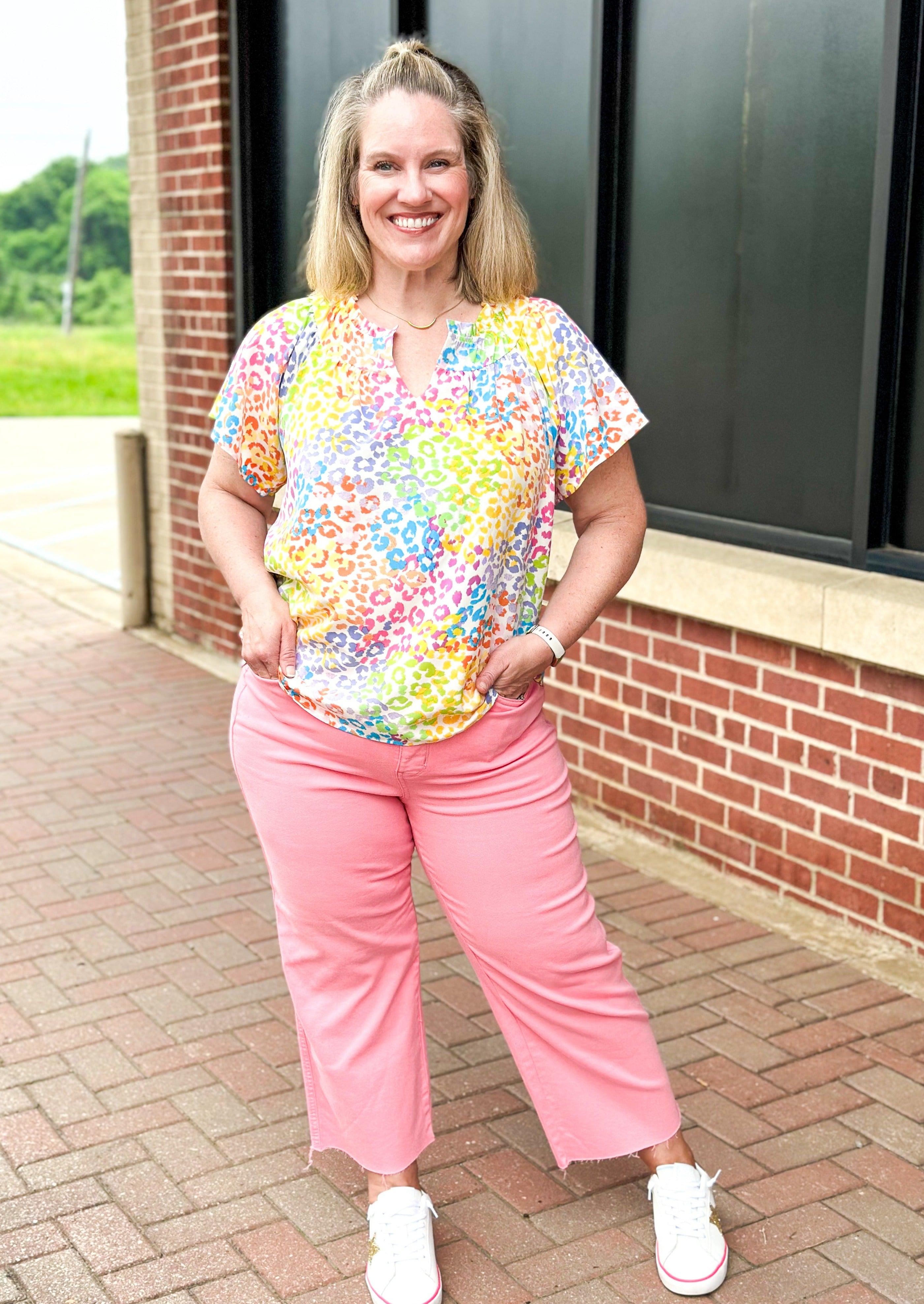 bright colored leopard print top - pinks, green, yellow, blue and orange leopard print on a white background - ruffle v-neck