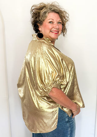 Shimmer Gold V-neck blouse with relaxed elastic short sleeves and a split hem at waist. 