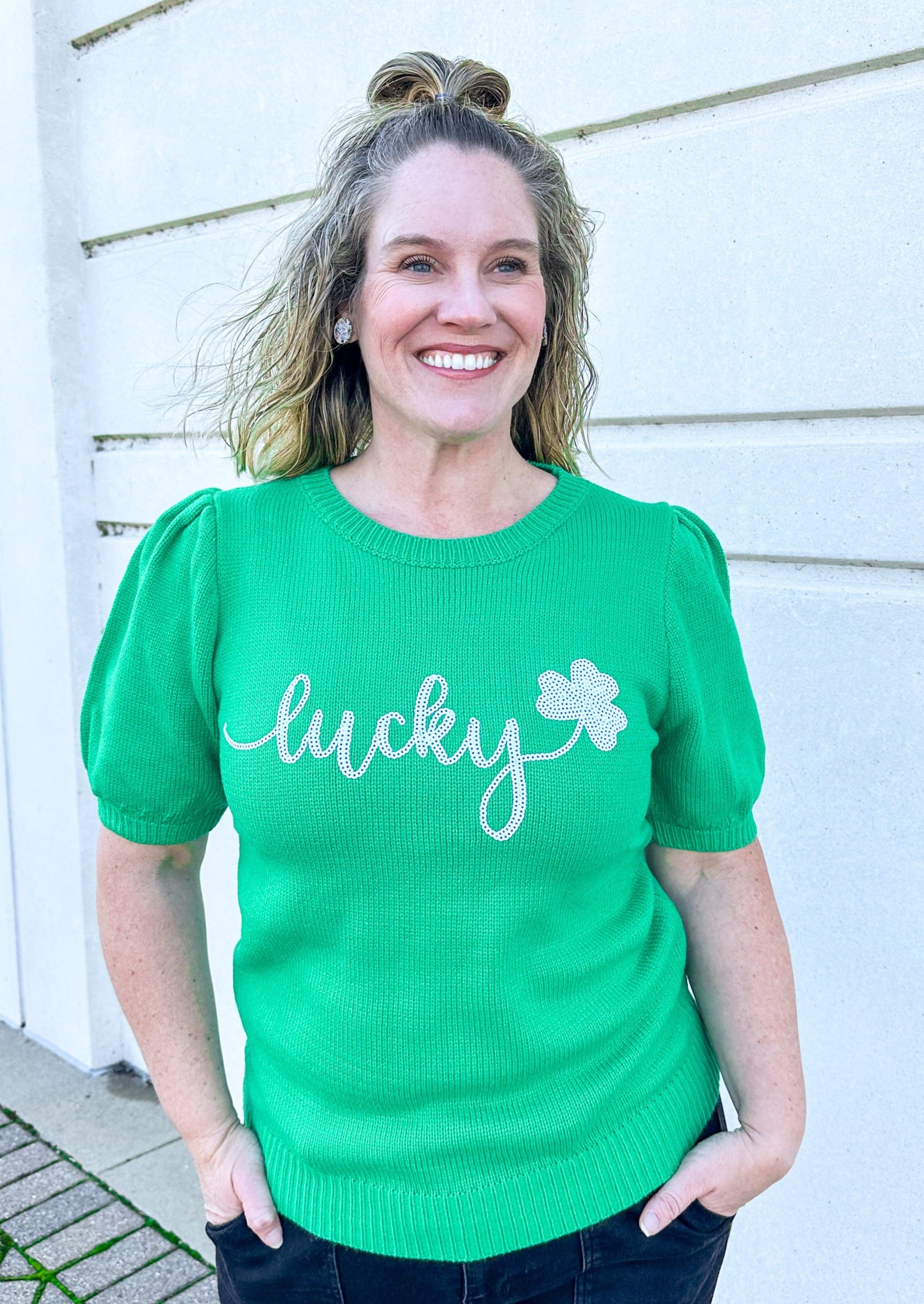 Kelley Green short sleeve sweater with bubble sleeve, lucky spelled in white sequin across the chest with a 3 leaf clover, banded arm and slightly banded hem