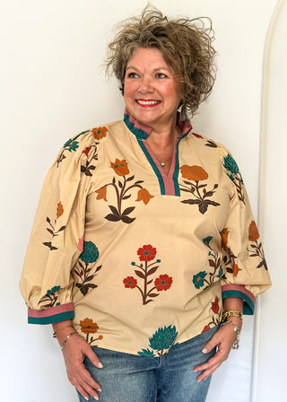 Ecru floral blouse with colorful flowers, contrast turquoise and rose trim, and ruffled neckline