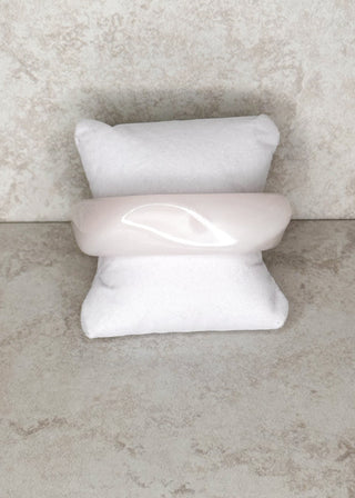 White bangle bracelet displayed on a stand 