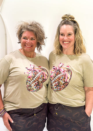 light brown soft tee with disco football with pink bow graphic on the front