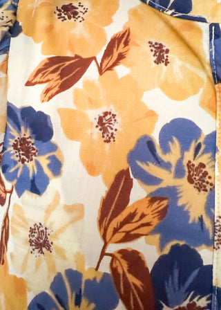 Bold Navy and golden blooms on this short sleeve top with navy ruffle detail on the sleeves, collar and 1/2 way down the front. Buttons up the front.