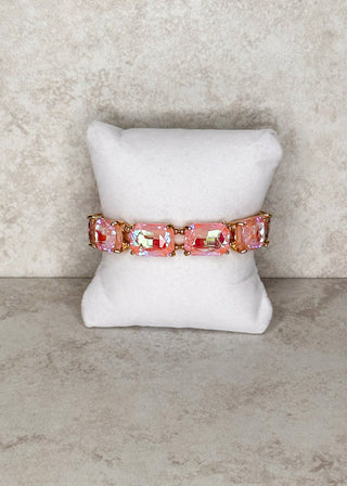 Peach gemstone bracelet displayed on a stand
