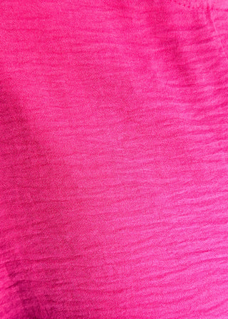 Close up of solid pink textured blouse with a V-notch neckline, short sleeves
