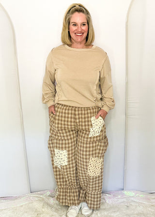 woman modeling gingham bloomer pants with patches and pockets.