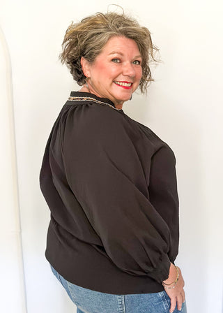 Textured black blouse with leopard lace detail on v-neckline and cuffs.