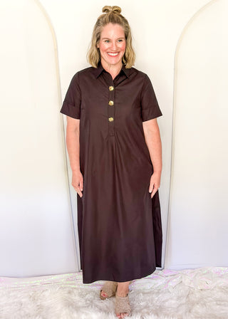 Casual black women’s dress with collared neckline, rolled sleeves, and decorative gold snaps