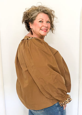 Mocha brown long-sleeve blouse with leopard print trim on neckline and cuffs.