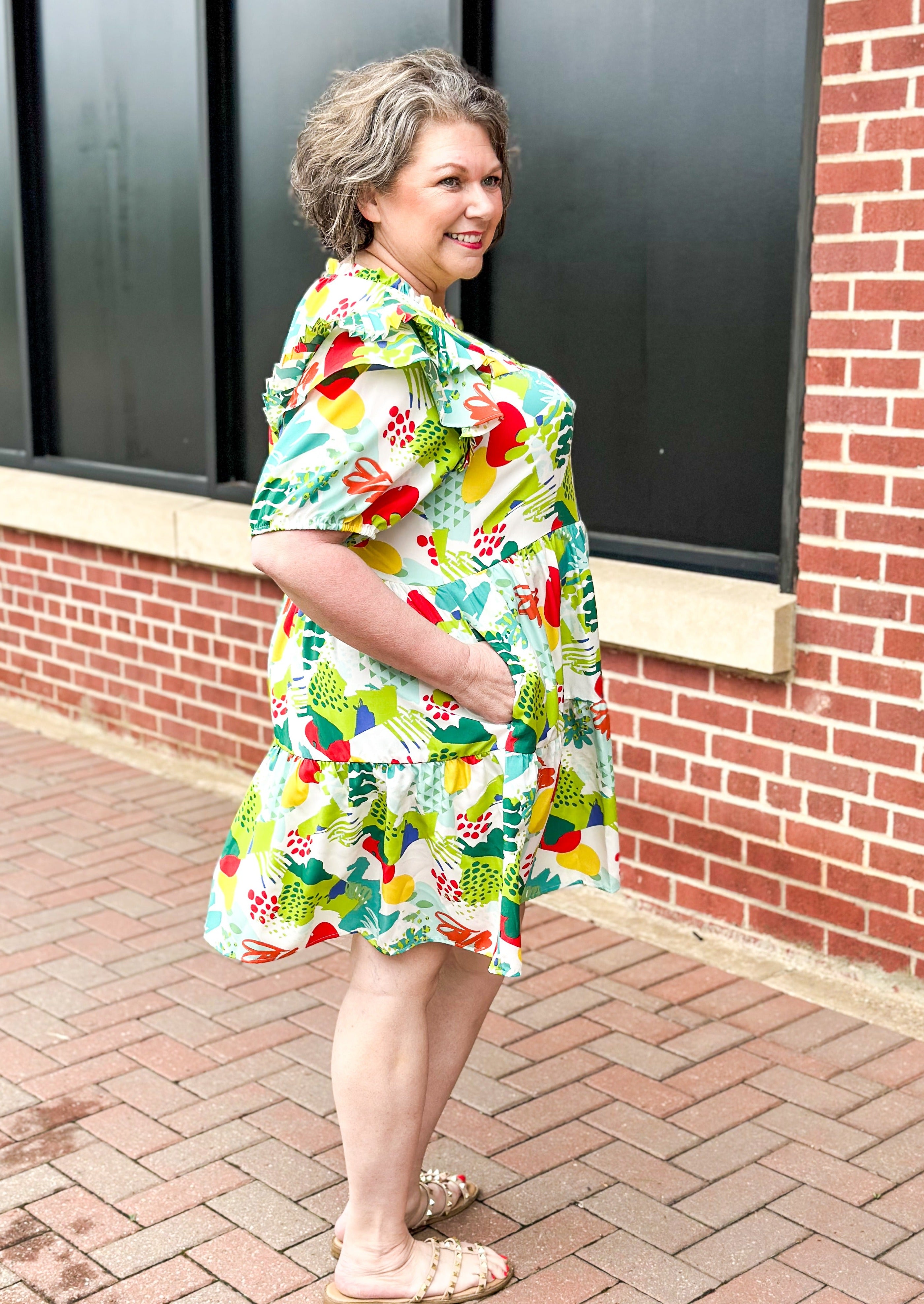 Greens, red, yellow, teal abstract print on white background dress - ruffle neck and ruffle on shoulder of short balloon sleeve - tiered