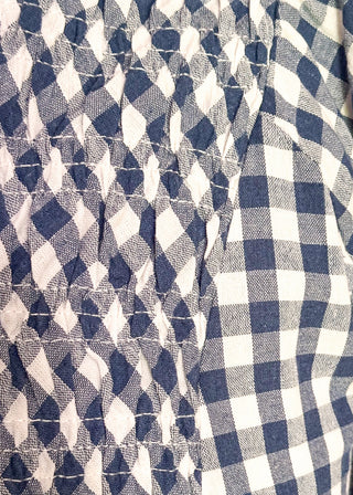 Woman wearing long blue gingham dress with short sleeves