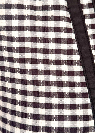 Close up of black gingham sleeveless dress with contrast trim neckline