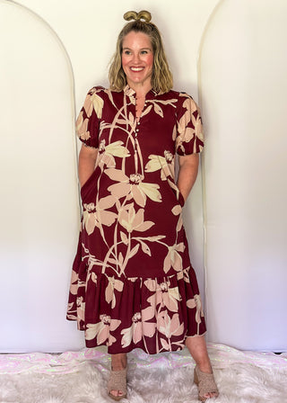 woman wearing tiered midi dress in Burgundy abstract floral print.