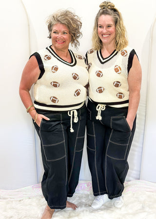 Black balloon style pants with rope drawstring waist. White stitching around pockets and crop cut.