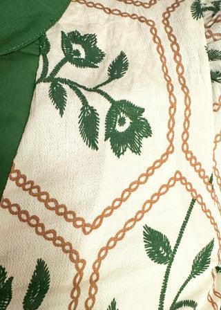 close up of neutral blouse featuring green florals with geometric hexagon pattern