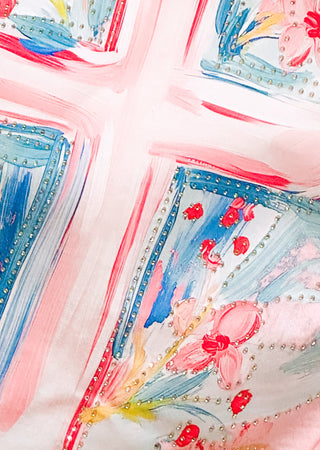 Close up of pink graphic tee with watercolor cross design and flat rhinestone accents