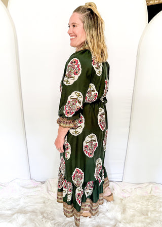 Palm green maxi dress with colorful floral medallion print, orange embroidered trim at neckline, and smocked cuffs