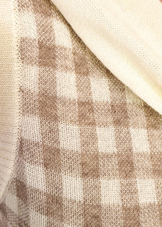 Close up of oatmeal checkered sweater with faux wrap in cream.
